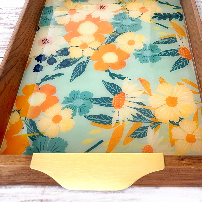 Floral-patterned serving tray with a gold handle on a wooden table