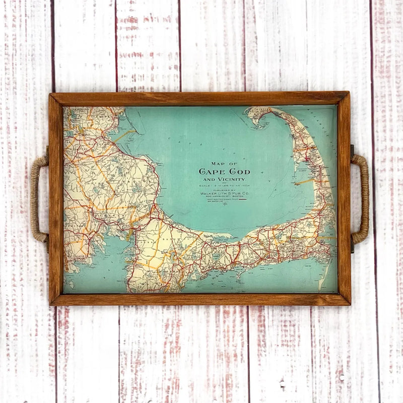Map of Cape Cod on a wooden tray with handles against a white wooden background. vintage map of cape cod massachusetts in a wooden serving tray with handles