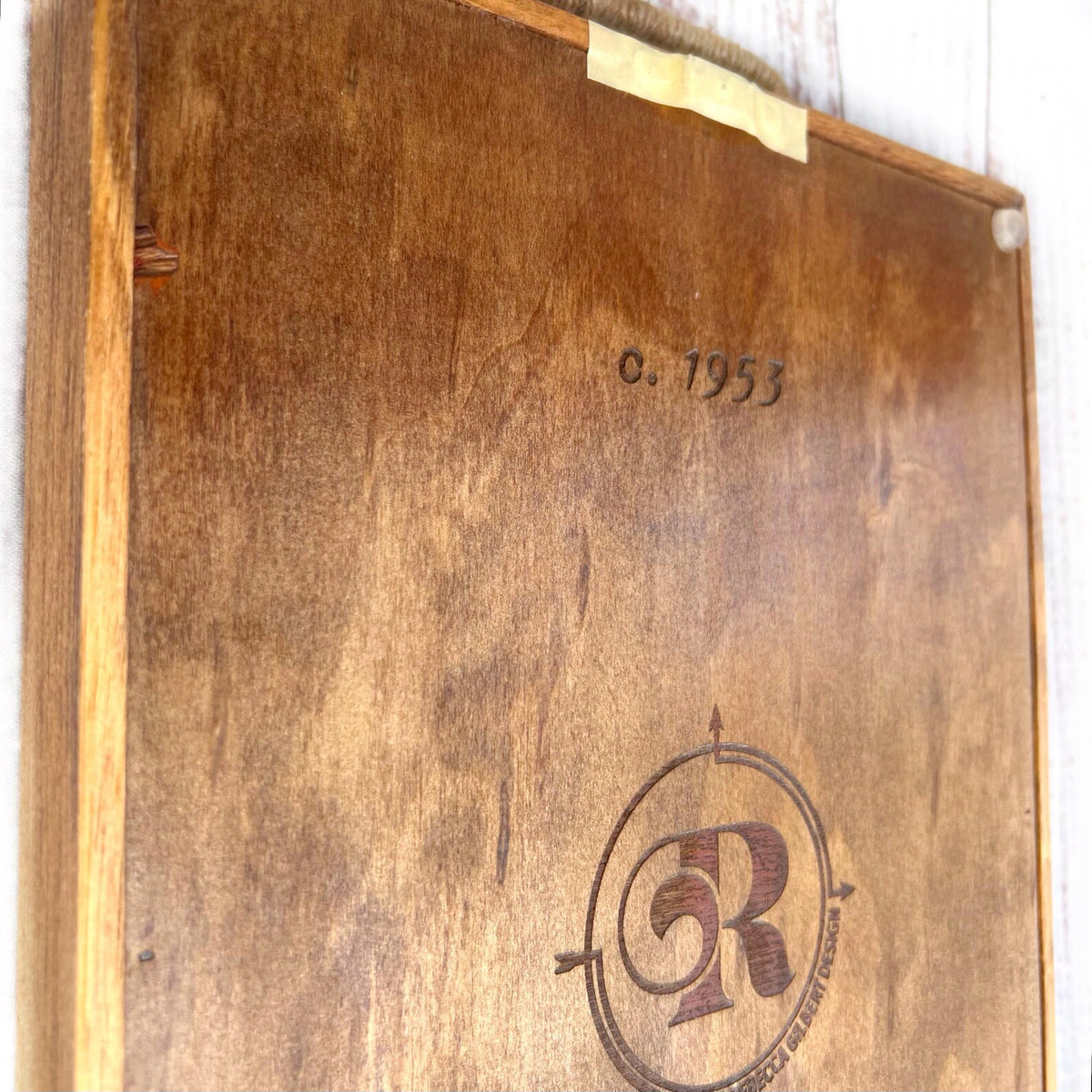 Wooden box with a logo and year of manufacture on a white background