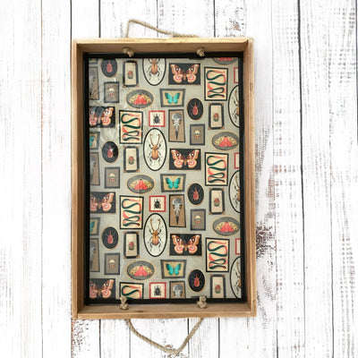 Framed artwork with butterfly designs on a wooden surface